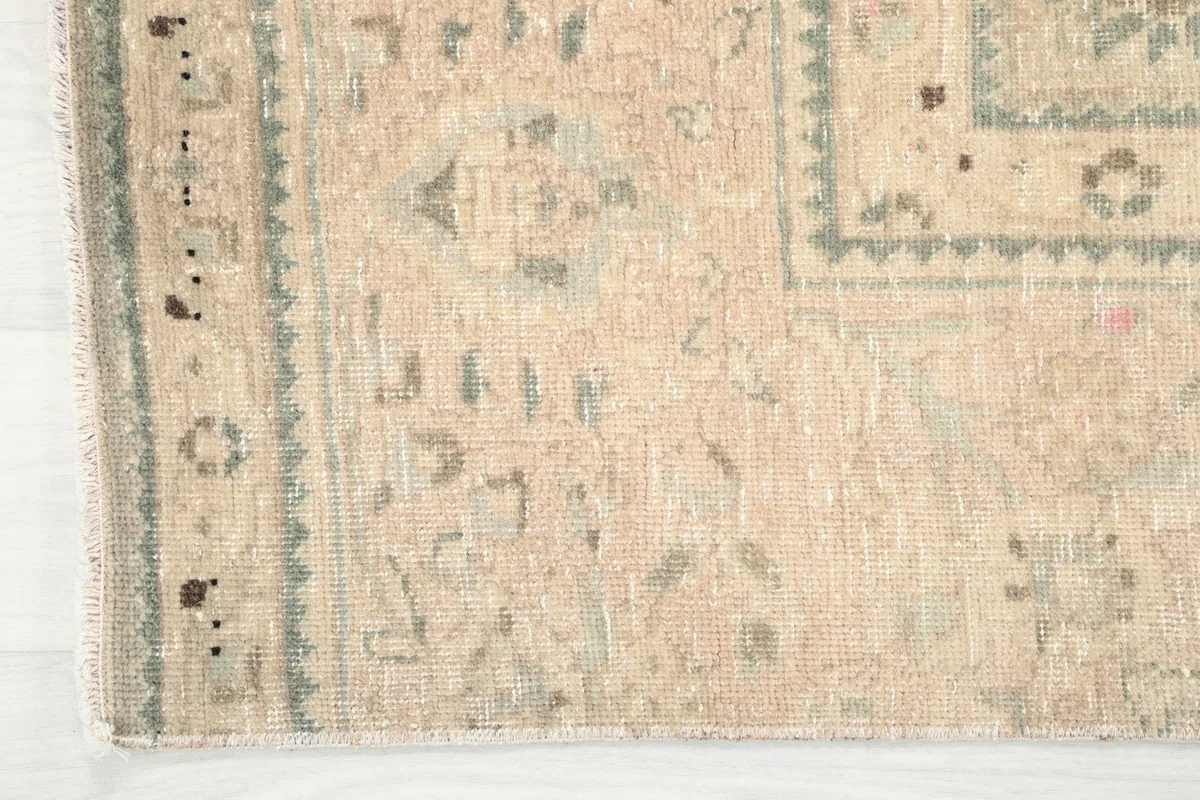 Close-up of the geometric border design and the edge finishing of the hand-knotted runner.