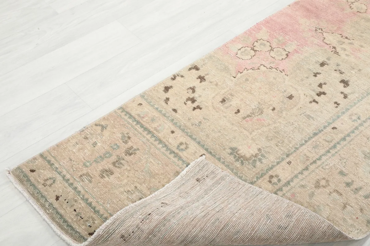 Corner of the runner rug folded back to show the construction and the reverse side.