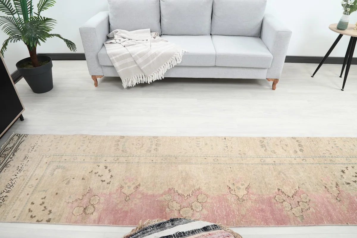 Overhead view showing the runner rug's pattern and color variation along its length in a room.
