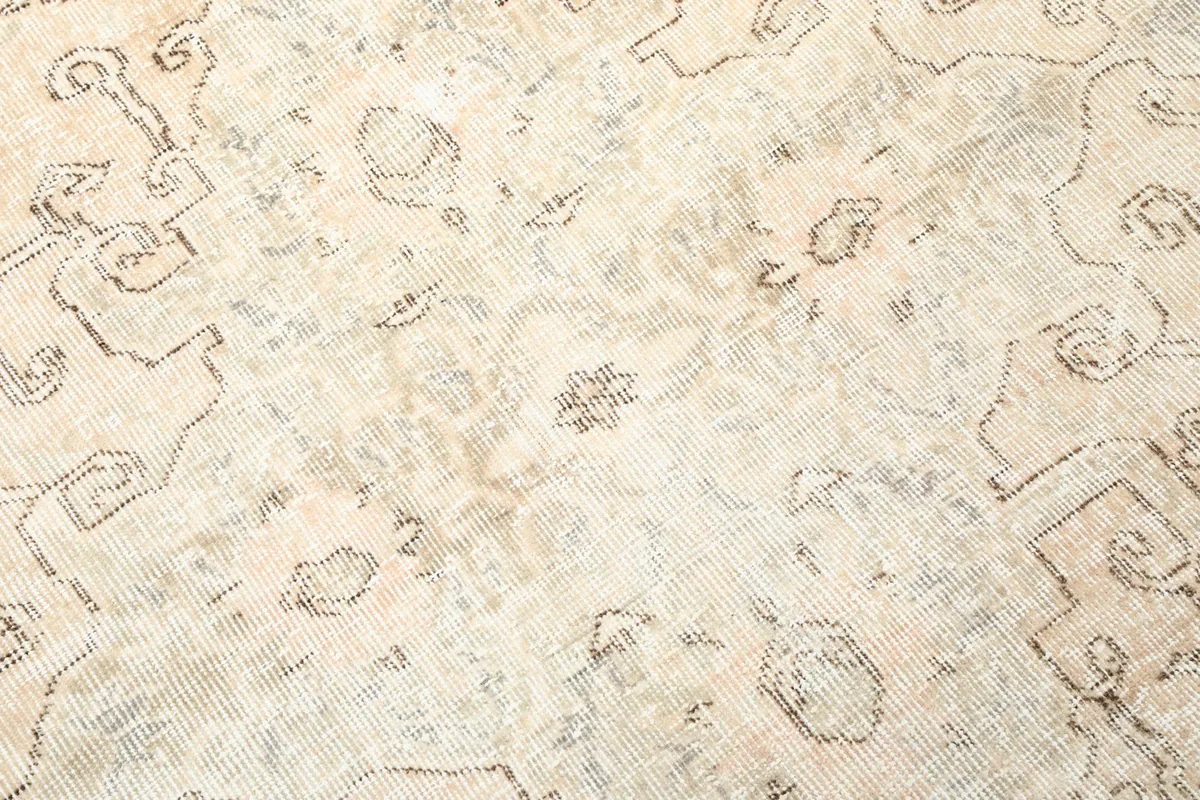 Intricate detail of the faded gray and beige wool pile texture and specific motifs.