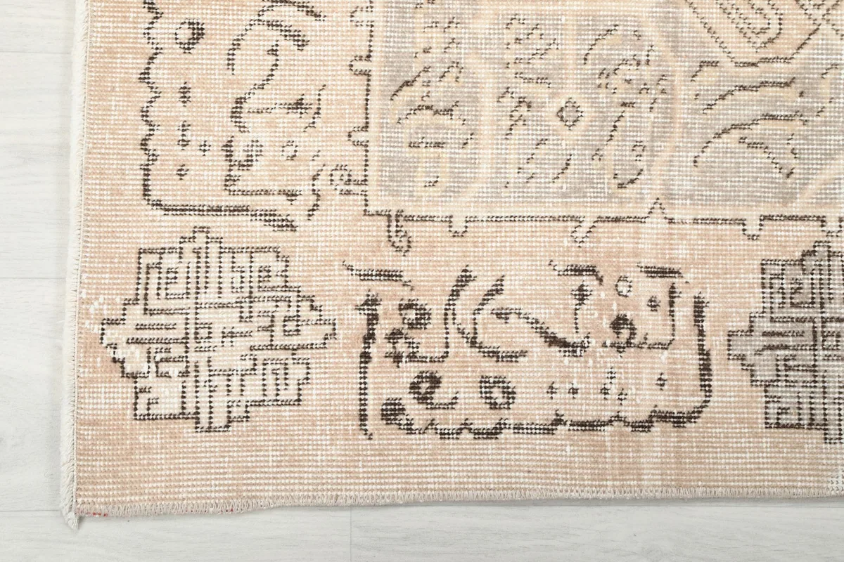 Corner detail showing the outer border pattern and fringe of the hand-knotted rug.