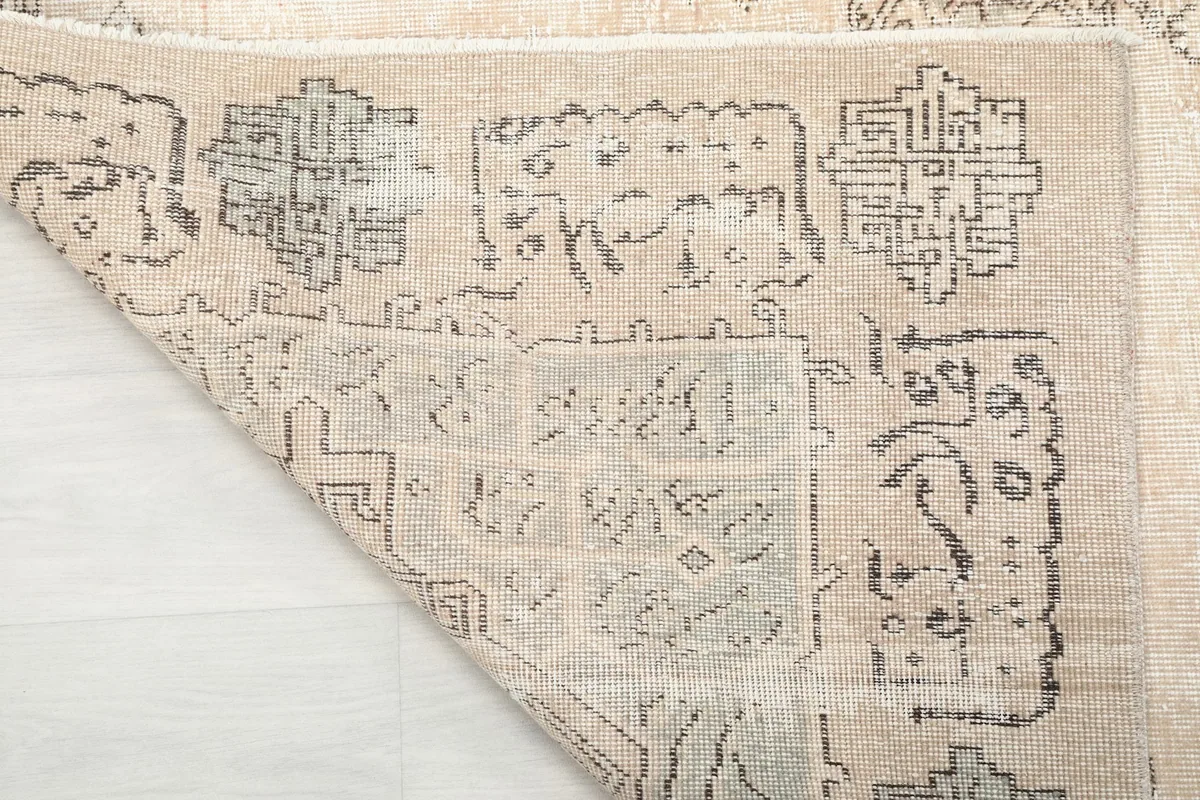 Close-up of the rug's reverse side, revealing the hand-knotted cotton foundation.