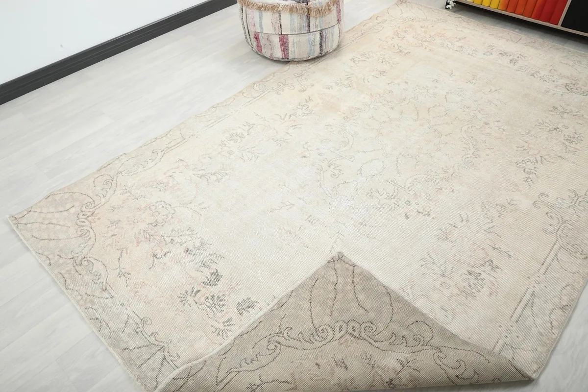 View of the rug with a corner folded back, revealing the reverse side of the hand-knotted foundation.