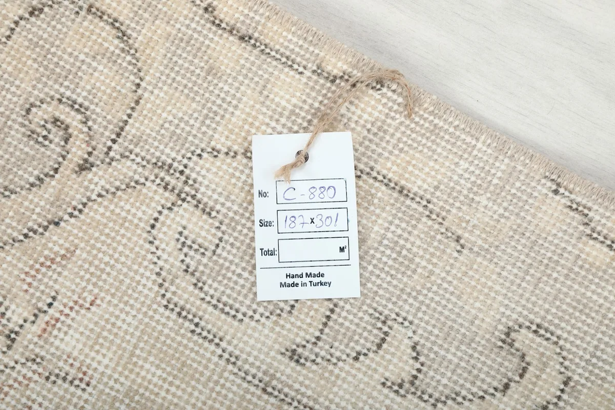 View of the rug's back with a tag displaying the item number and size (187x301 cm).