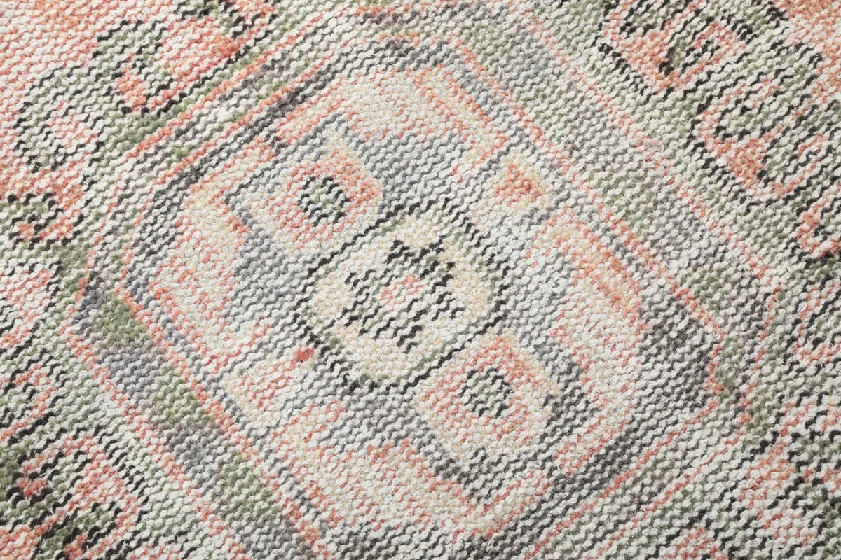 Extreme close-up of the intricate geometric patterns within a medallion, revealing the individual wool knots and colors.