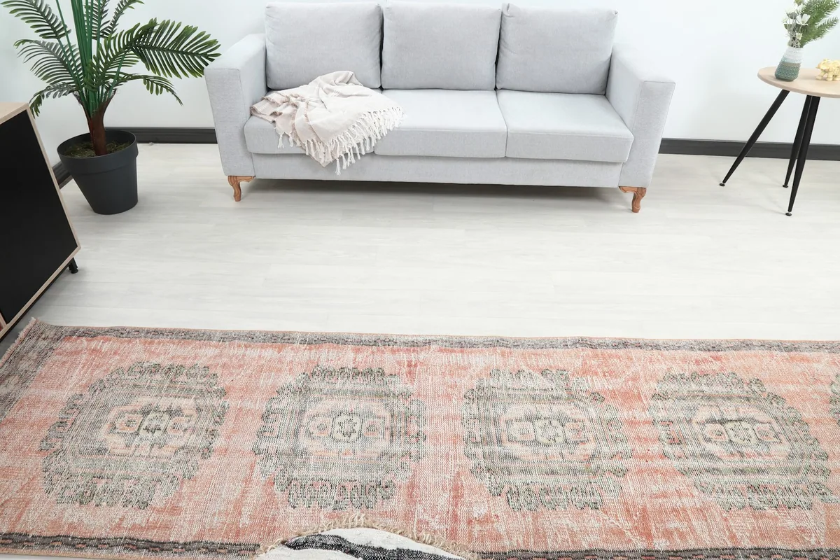 Overhead view of the rose and gray runner rug, highlighting its full length and medallion patterns in a room setting.