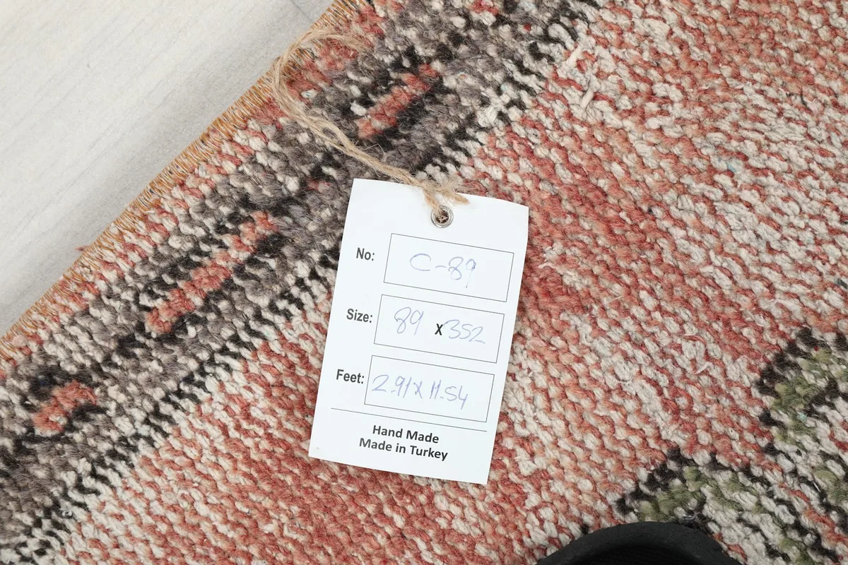 Close-up of the rug's corner with a product tag indicating size and 'Hand Made in Turkey'.