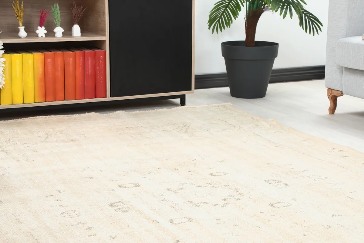 Close-up view of the rug's subtle beige and cream tones near a cabinet