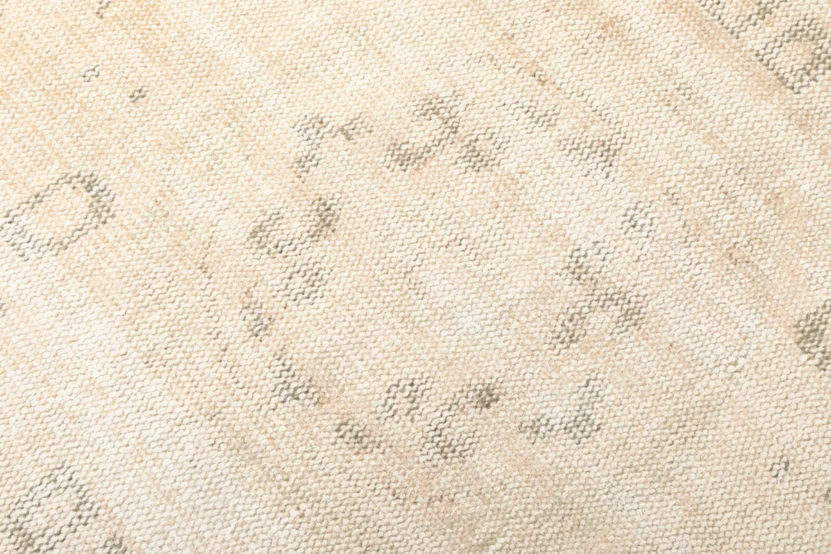 Detailed view of the hand-knotted wool pile and subtle gray motifs