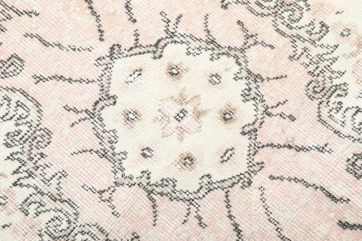 Very close detail of the hand-knotted wool pile, highlighting the texture and subtle color shifts in the medallion.