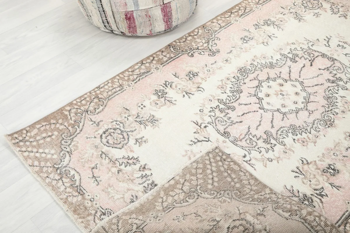 View of the rug folded to show its flexibility and the detail of the corner and fringe.