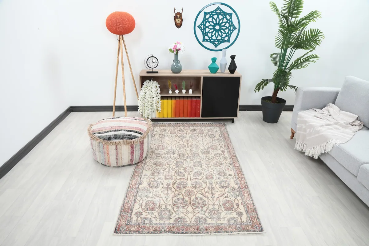 Vintage Anatolian rug displayed in a bright living room setting with a light gray couch and wooden furniture