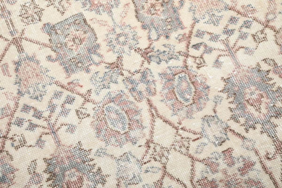 Close-up of the intricate floral and vine motifs with subtle color variations and vintage wear