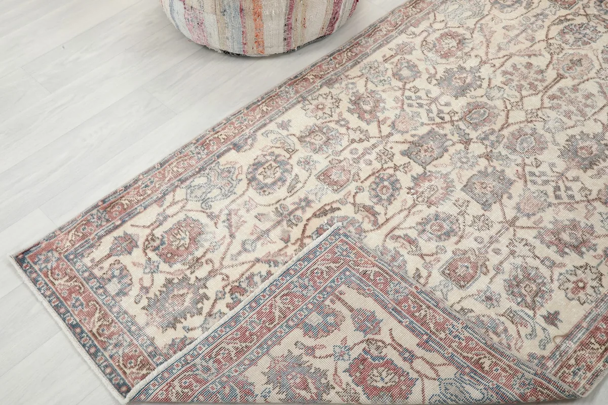 Rug corner folded back slightly, revealing the underside and the hand-knotted construction