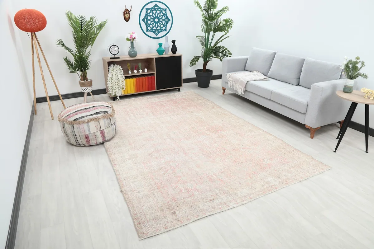Angle view of the rose and ivory area rug in a modern living space, showing its size relative to furniture.