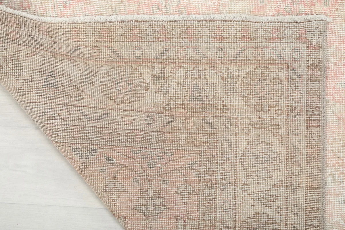 Close-up of the rug's cotton foundation and the reverse side of the hand-knotted wool pile.