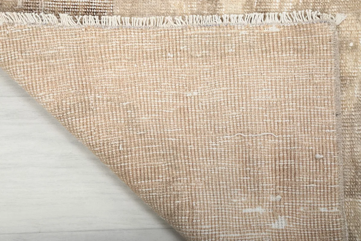 View of the back of the rug, showing the intricate hand-knotted cotton foundation.