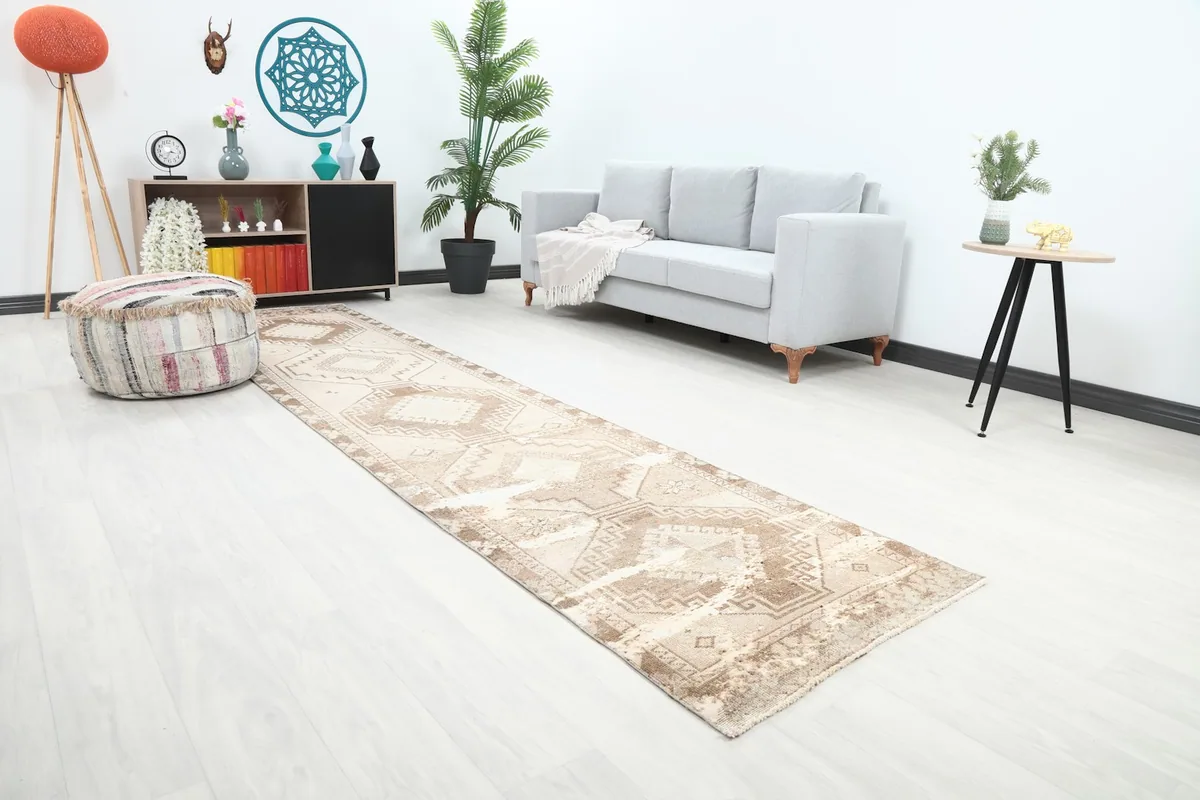 Angle view of the cream and brown geometric runner rug in a room, highlighting its length and pattern