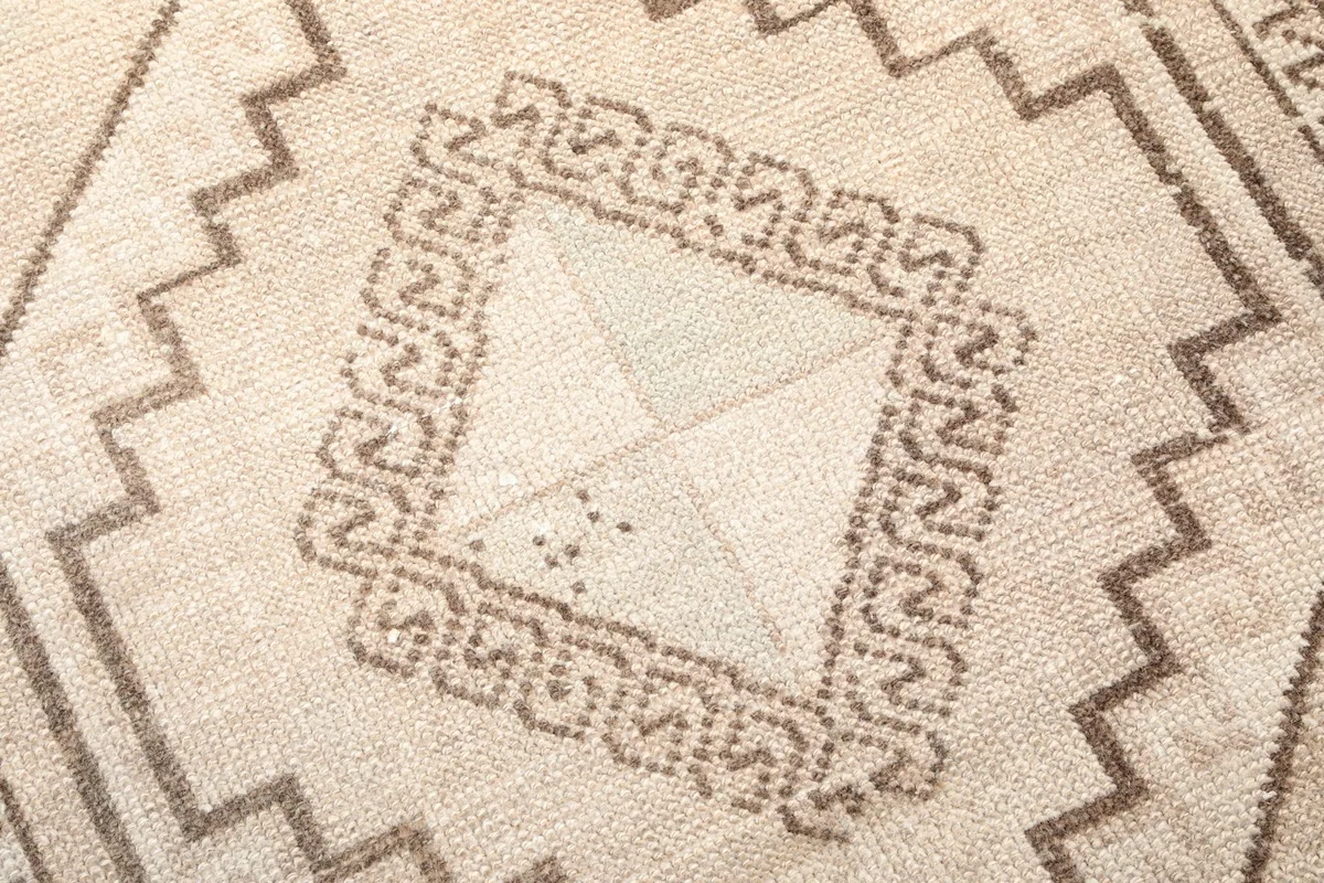 Extreme close-up of the hand-knotted wool pile, showing texture and subtle color shifts within a motif
