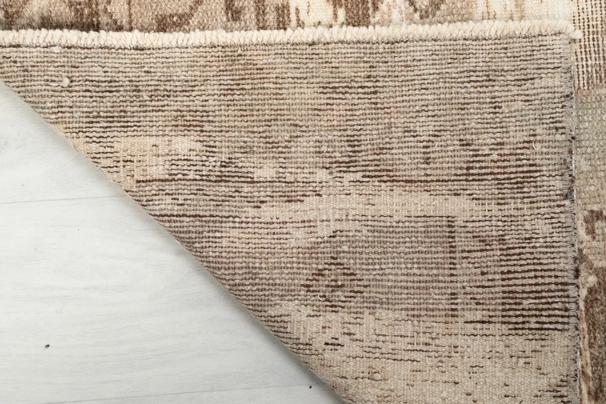 Underside view of the rug, clearly showing the tightly woven cotton foundation and knotting structure