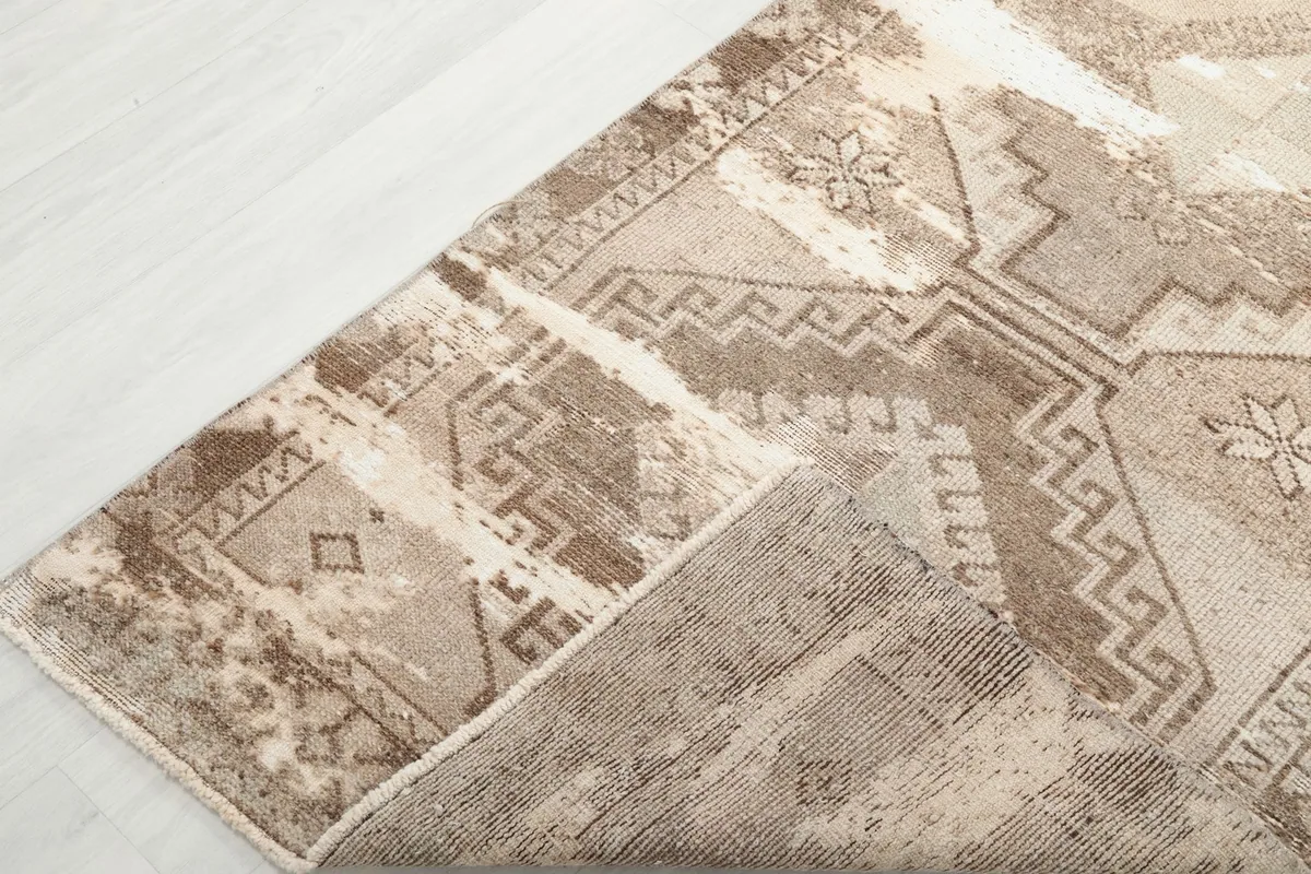 Corner of the rug folded back to show the reverse side of the hand-knotted wool on cotton foundation
