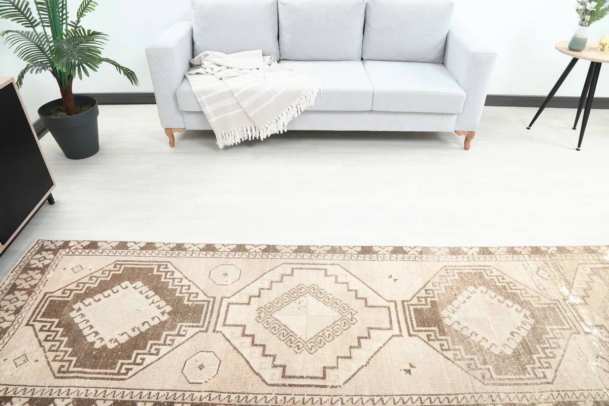 Overhead view showing the repeating geometric patterns and color variations of the vintage Anatolian runner