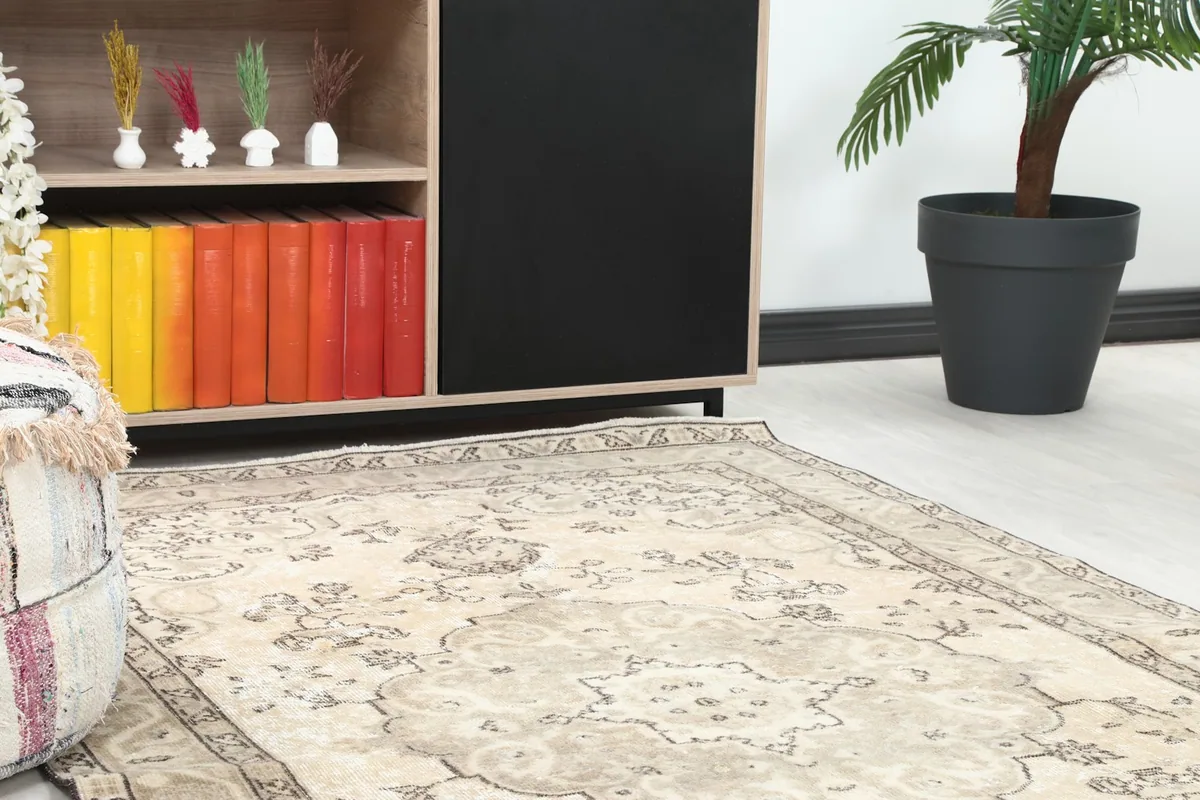 Close-up view of the vintage rug's edge and central medallion design within a room setting.