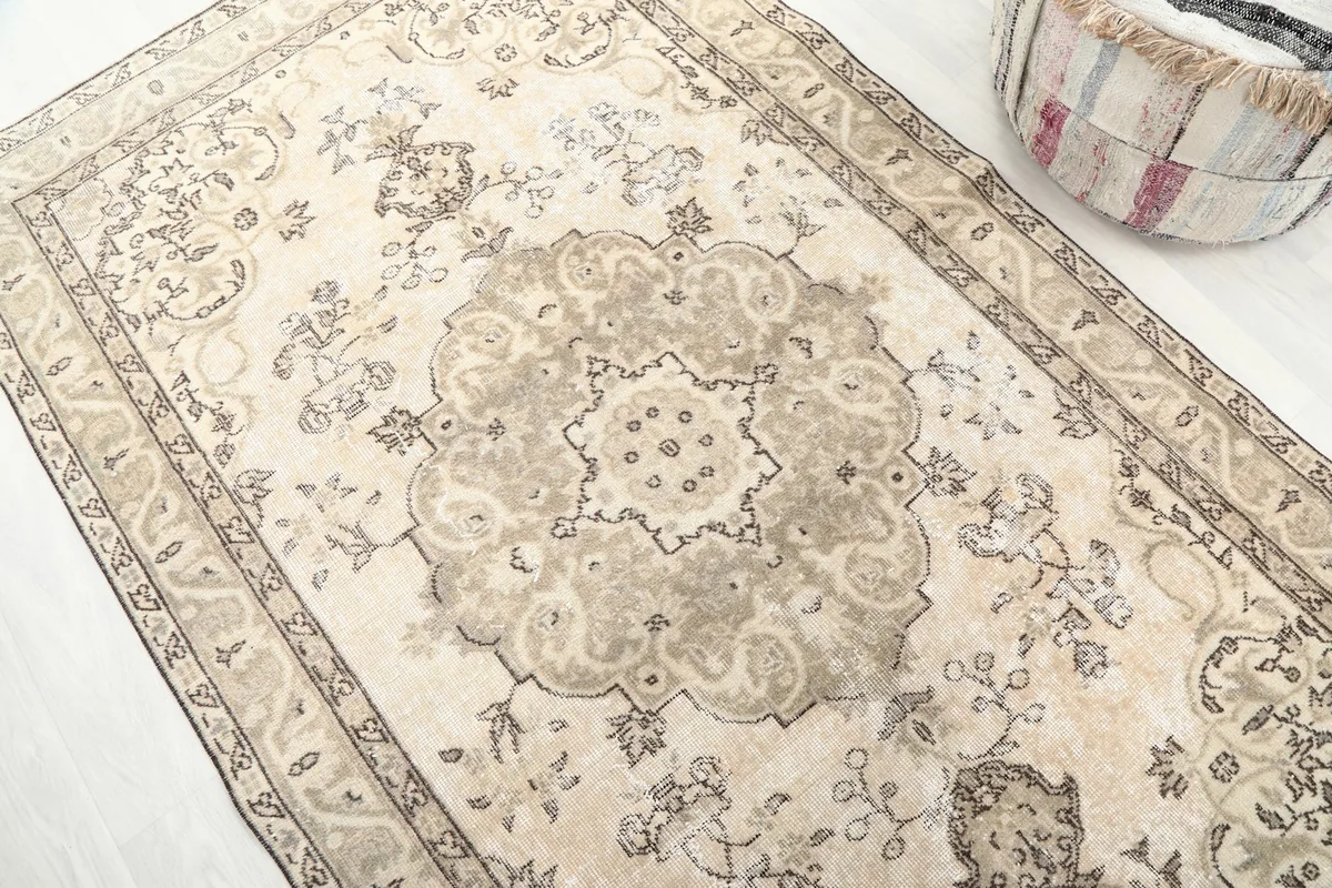 Detailed perspective of the central medallion and surrounding floral elements of the vintage wool rug.