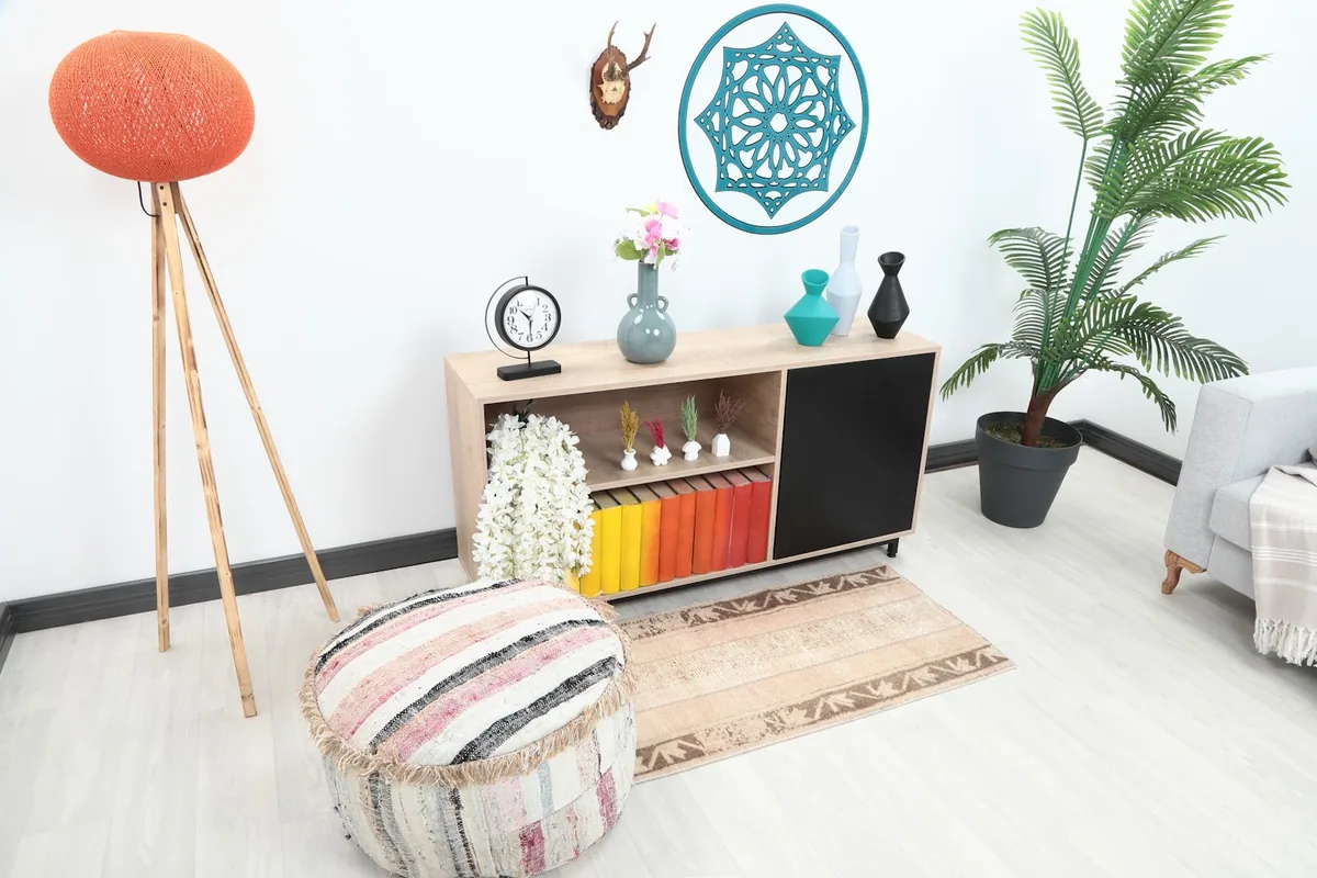 Anatolian area rug grounding a seating area with a striped ottoman and light gray sofa.