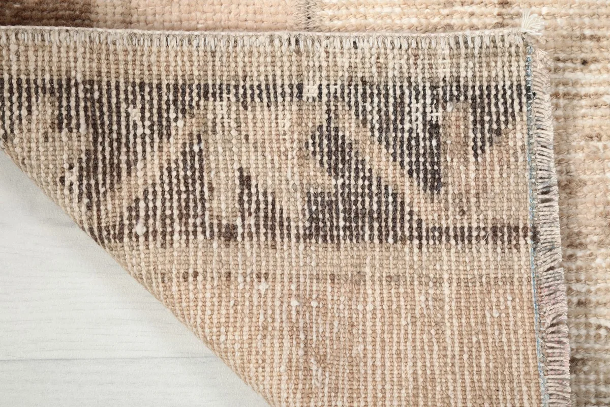 Underside of the rug, displaying the tightly woven cotton foundation and knotting.