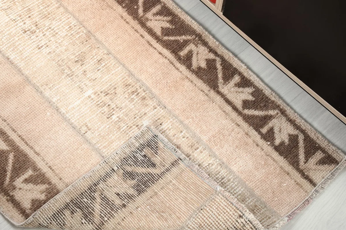 A corner of the rug folded back to show the hand-knotted construction and foundation.