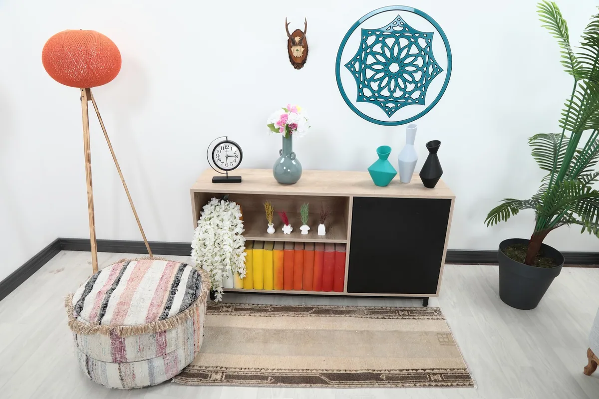 Vintage beige and brown rug styled in a living space with a wooden console and colorful books.