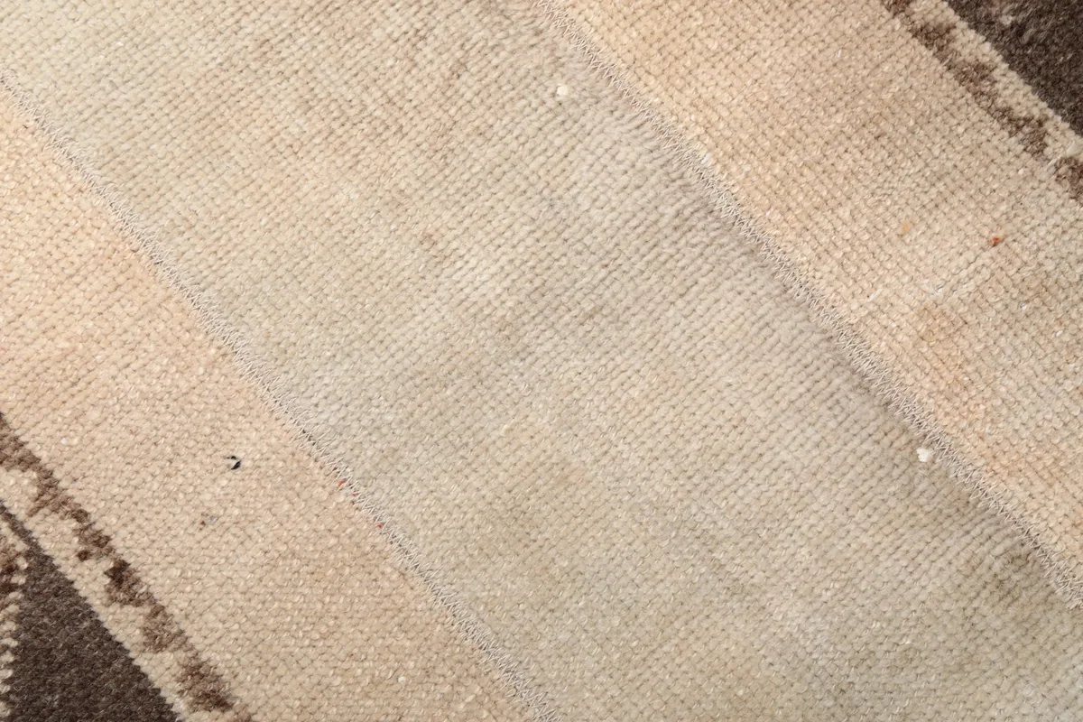 Close-up of the rug's low wool pile texture, showing the hand-knotted construction and natural wear.