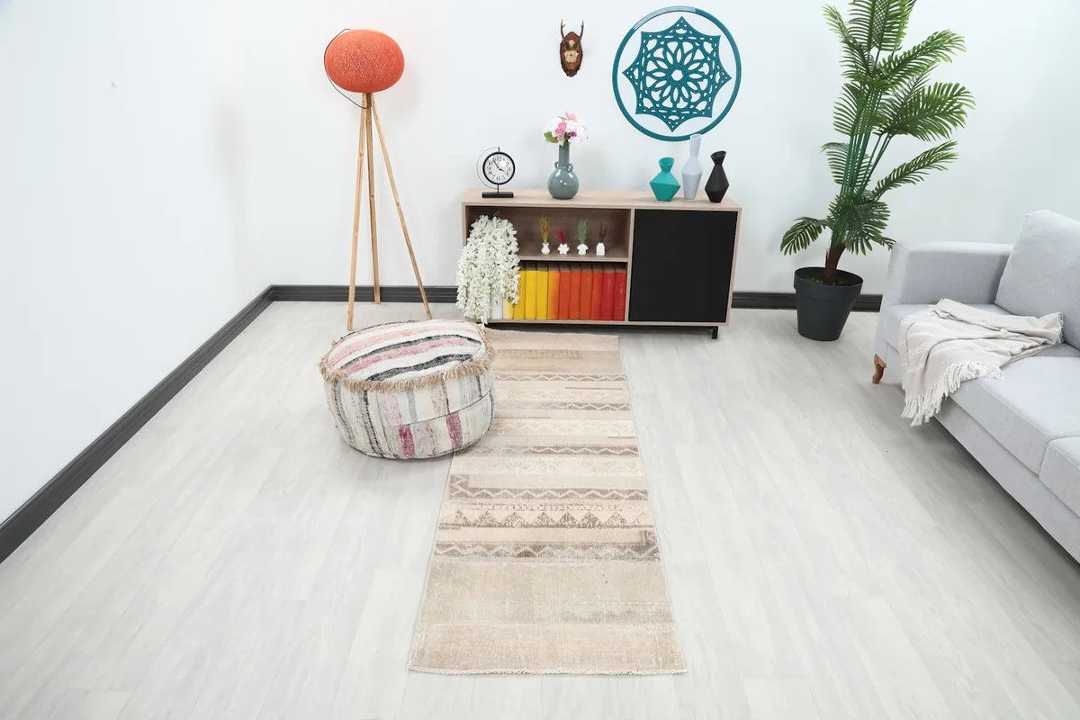 Vintage tan runner rug in a modern room setting with a light-colored floor, showing its length and design