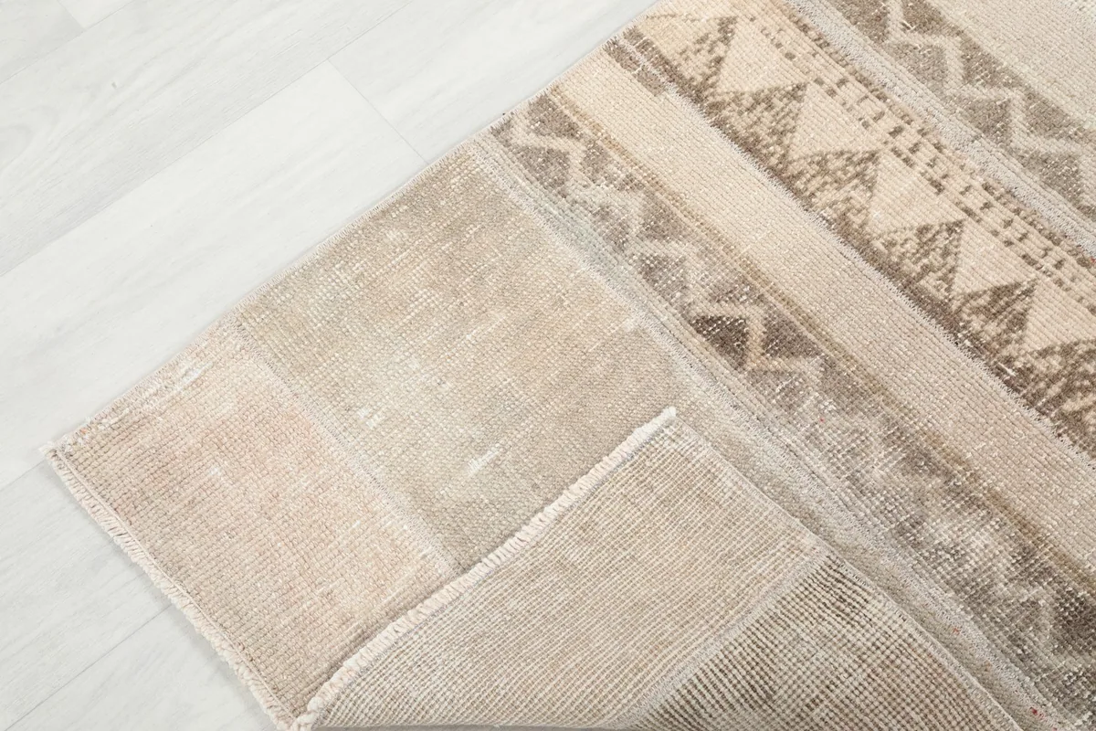 Corner of the runner rug folded to reveal the reverse side and the hand-knotted construction
