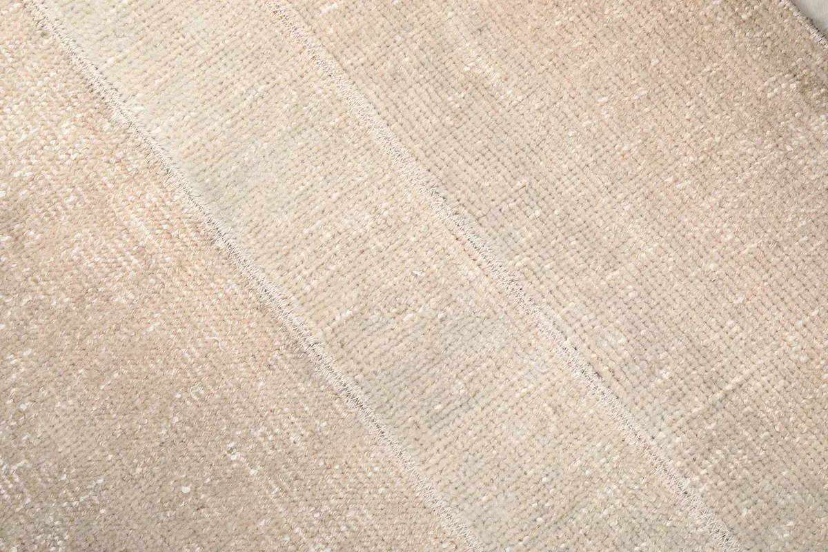 Detailed close-up of the Faded Beige Minimalist Anatolian Rug's low pile and weave texture.
