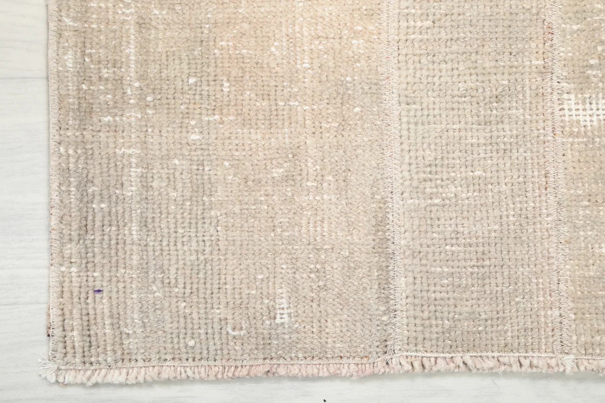 Close-up of the Faded Beige Minimalist Anatolian Rug's edge, showing the subtle fringe and weave.
