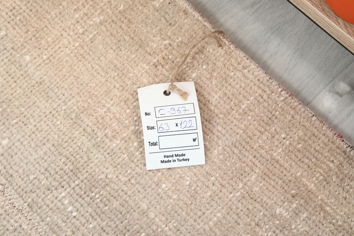 Product tag on the back of the Faded Beige Minimalist Anatolian Rug, displaying size and origin details.