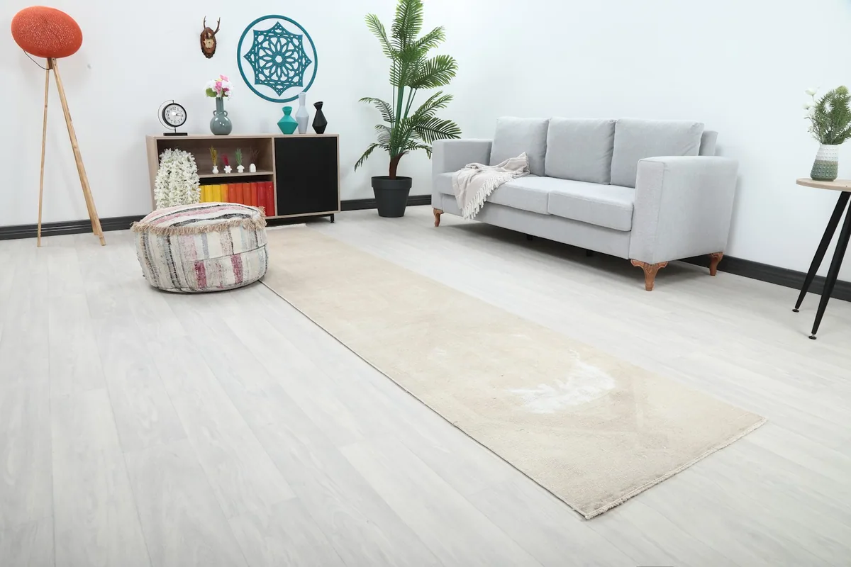 Angle view of the cream runner rug in a living space with a sofa and decor