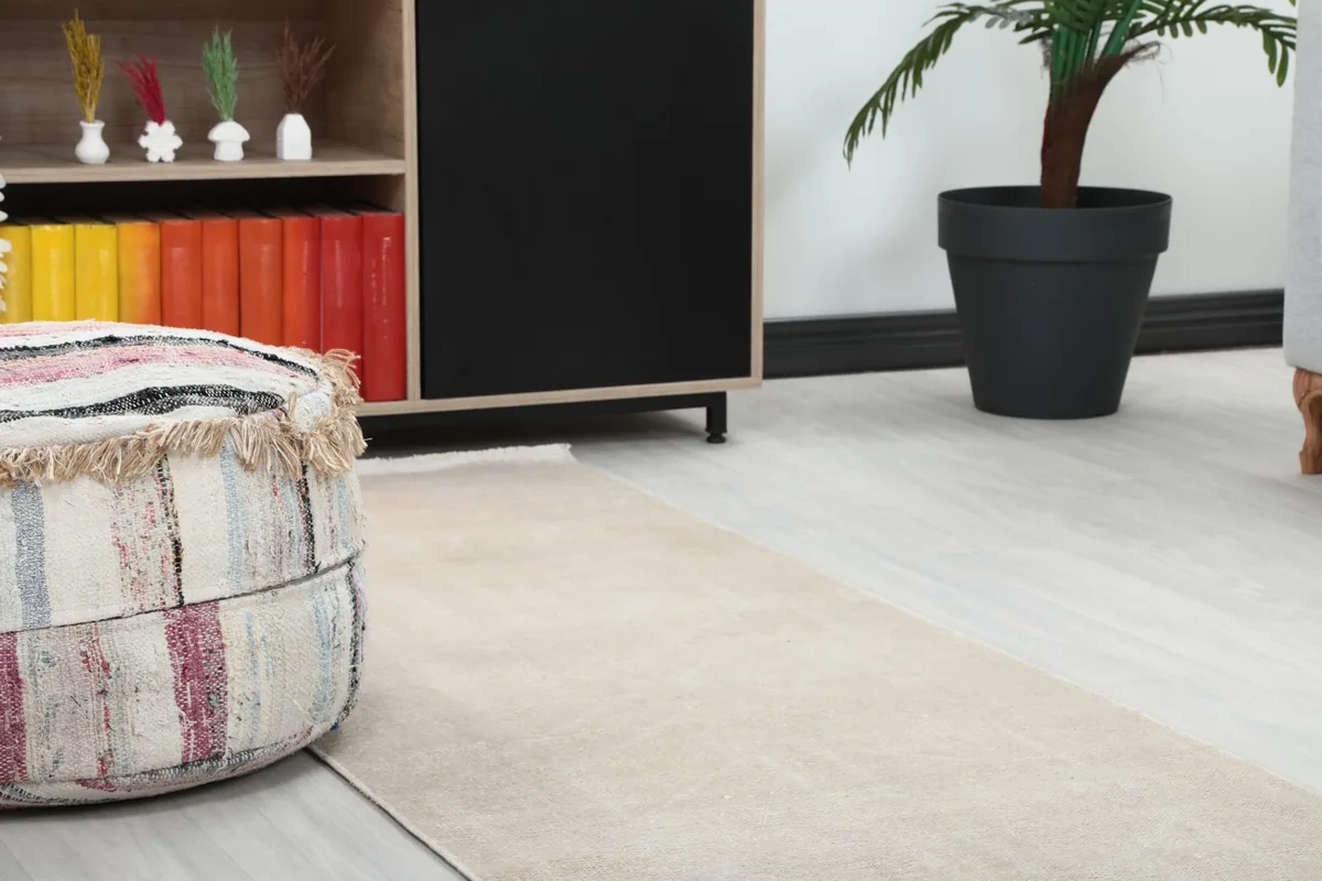 Close-up of the runner rug next to a decorative pouf and wooden furniture
