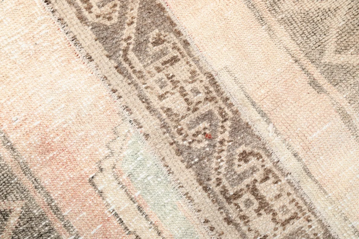 Close-up of the hand-knotted texture and muted colors in the rug's pile