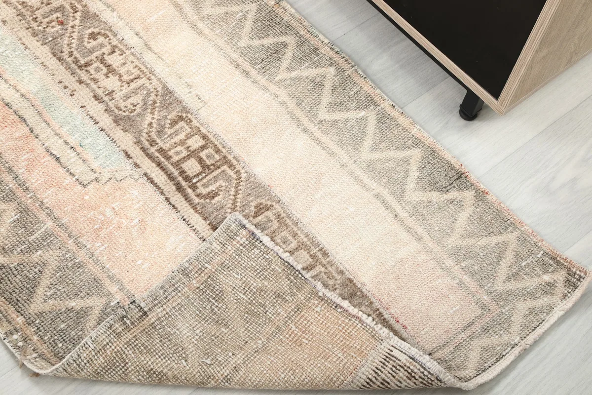 Corner of the rug folded to show the cotton foundation and hand-knotted reverse