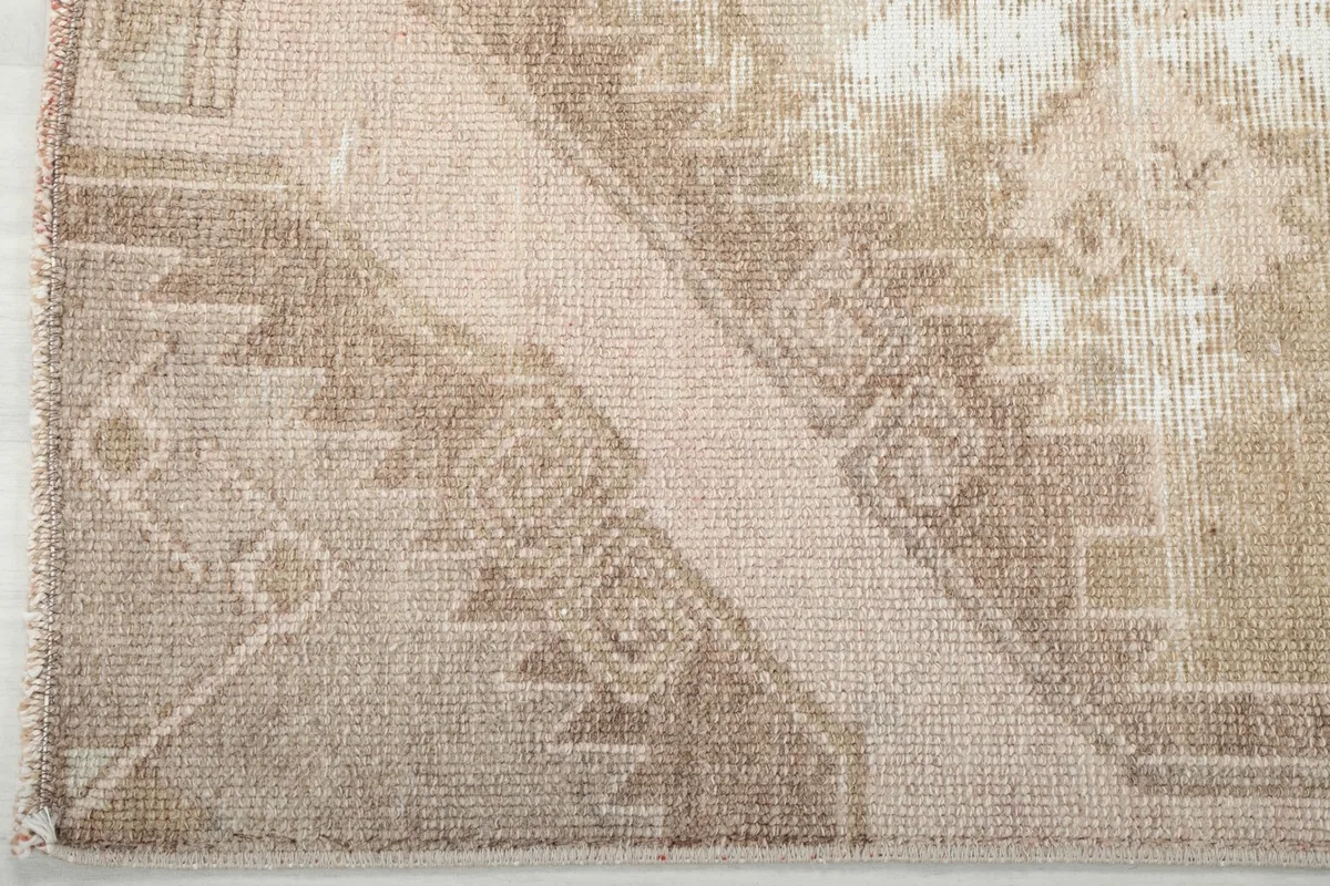 Corner detail of the runner rug, showing the geometric border design and hand-knotted construction