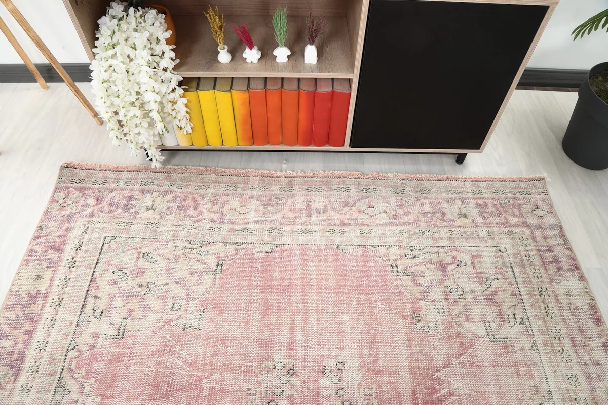 Detail of the rug's border and central design, seen from above in a room setting