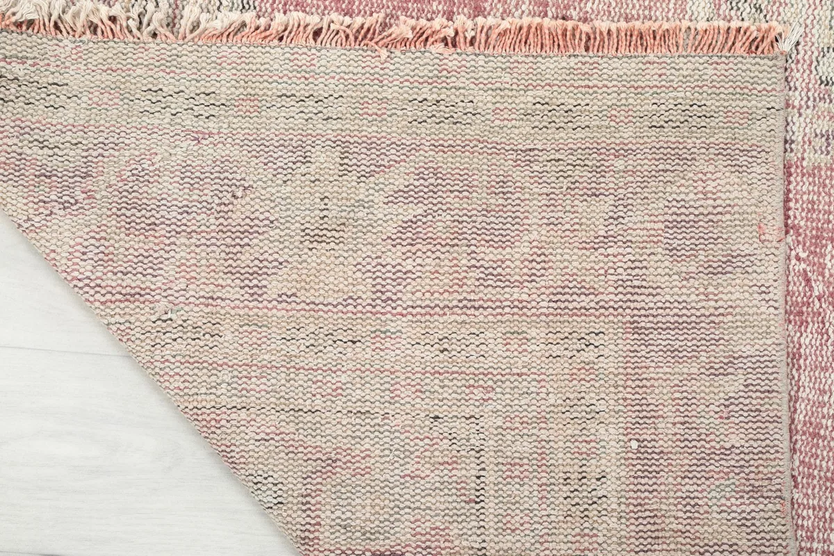 Close-up of the rug's back, showing the tightly woven cotton foundation and knotting structure
