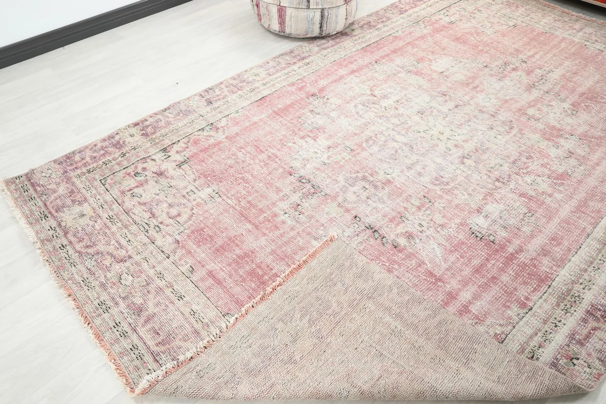 View of the rug with a corner folded back, revealing the cotton foundation and underside texture