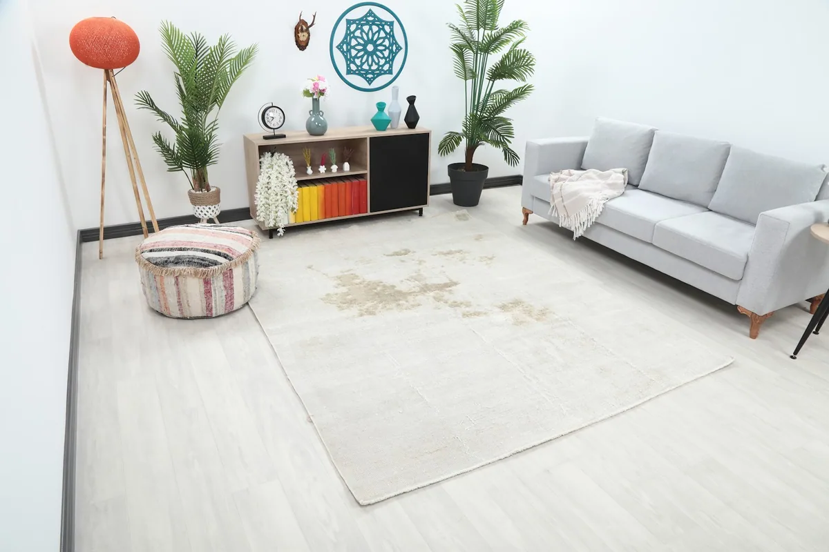 Angle view of the ivory and beige vintage rug in a living room, showing its placement relative to furniture.