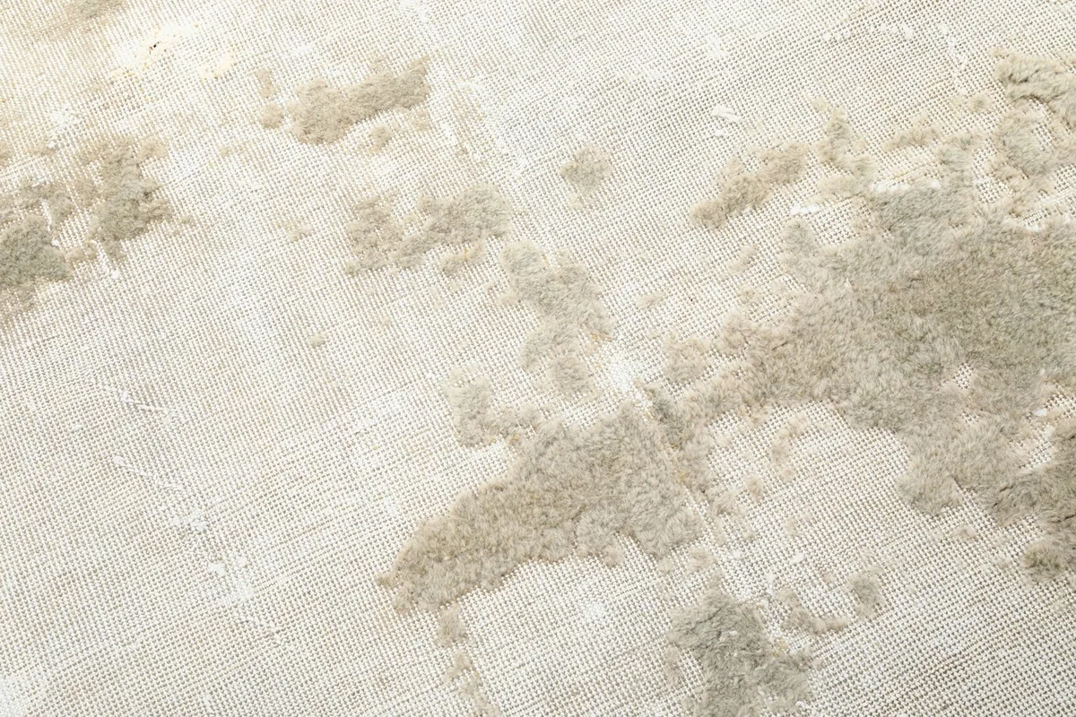 Detailed view of the hand-knotted wool pile, showing the subtle color variations and distressed character.