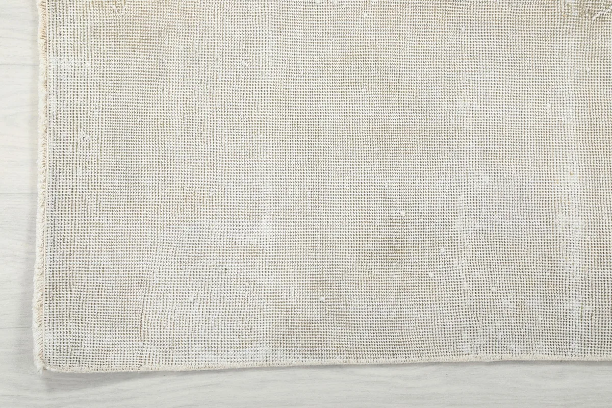View of the back of the rug, showing the cotton foundation and the tightly woven knots.