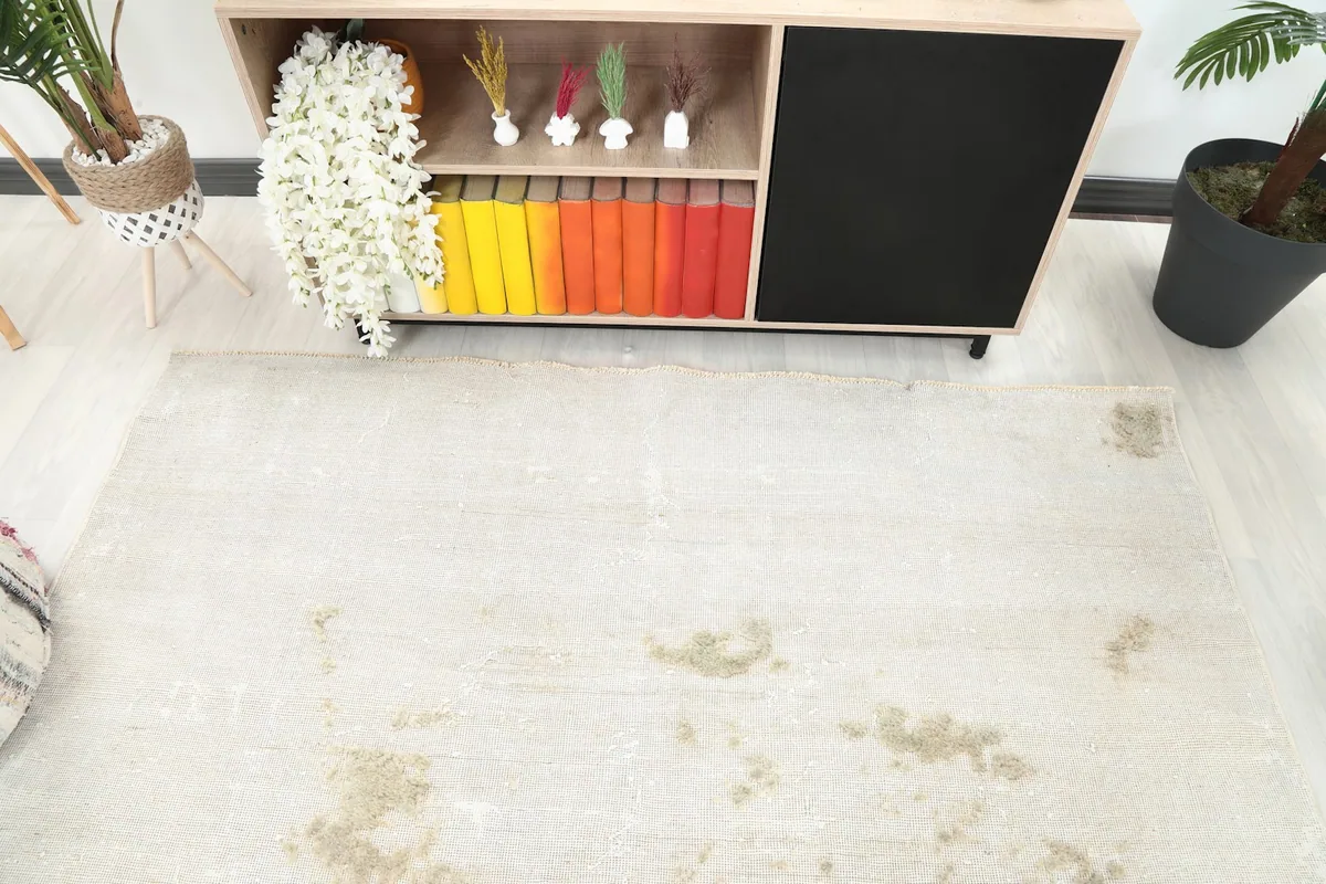Overhead view of the vintage rug in the room setting, showing its full spread and distressed areas.